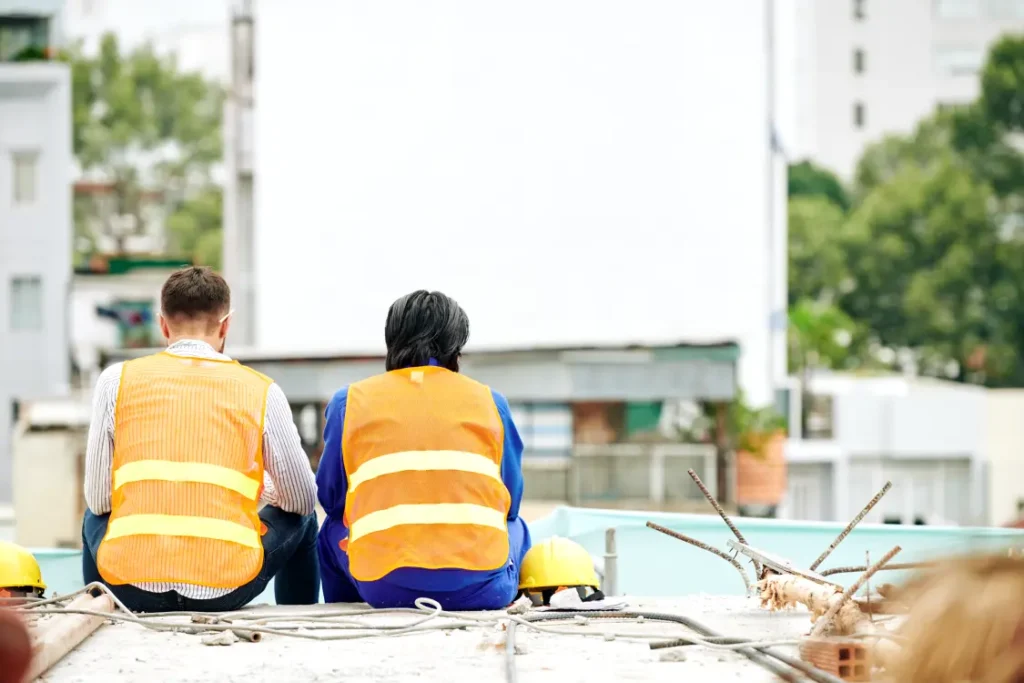 trabalhadores da construção civil descansando em uma marquise