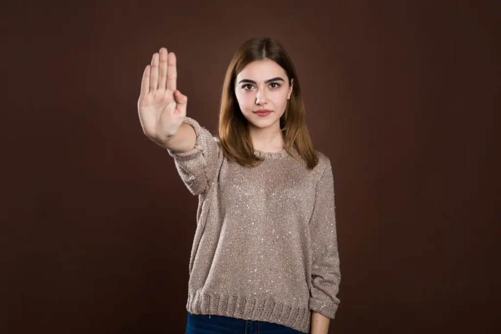 Mulher com a palma da mão estendida em sinal de pare
